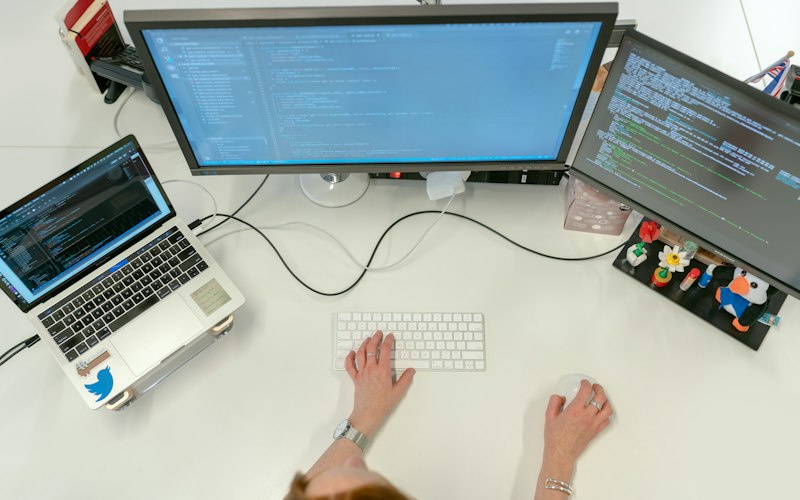 Iemand werkt aan een computer met toetsenbord en beeldscherm