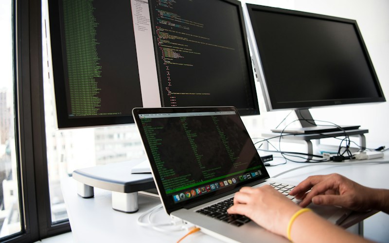 Laptop en beeldscherm met programmacode